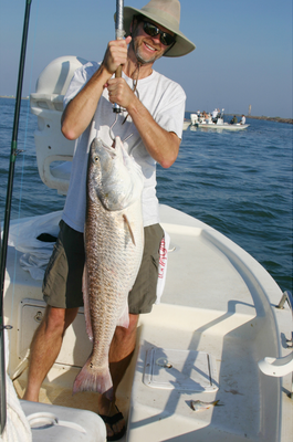 Angler with bull redfish caught from a boat