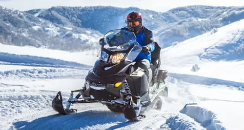 Photo of man driving snowmobile