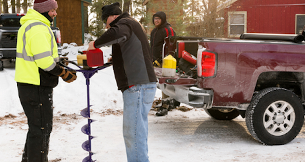 Photo of two men refueling a gas powered ice auger