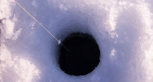 Photo of ice hole with fishing line running down into it