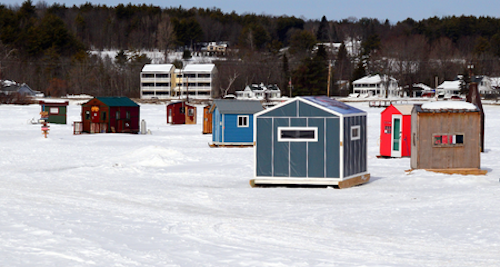 Photo of ice shanty village on frozen lake