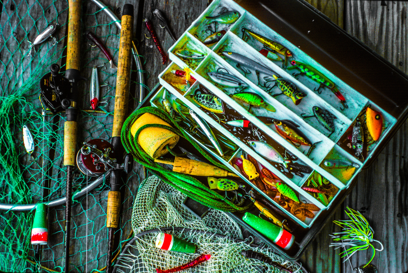 Photo of fishing tackle assortment, including rods, reels, lures, and tackle box