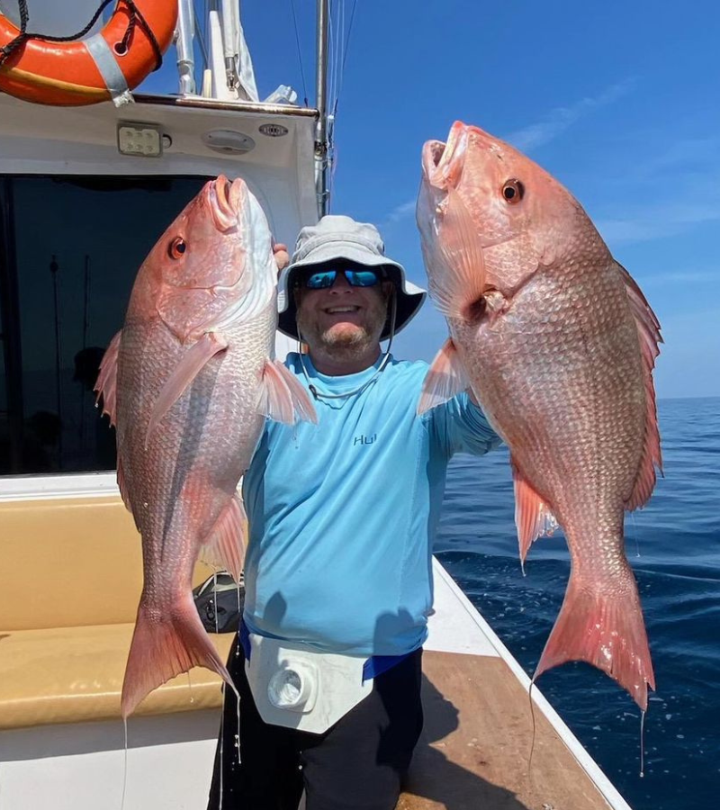 Photo of an angler holding two red snappers caught with a paternoster rig