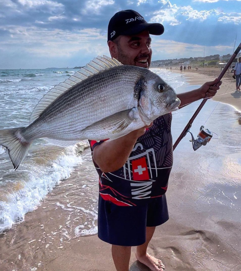 Photo of angler at the beach holding a sea bream caught with a flapper rig
