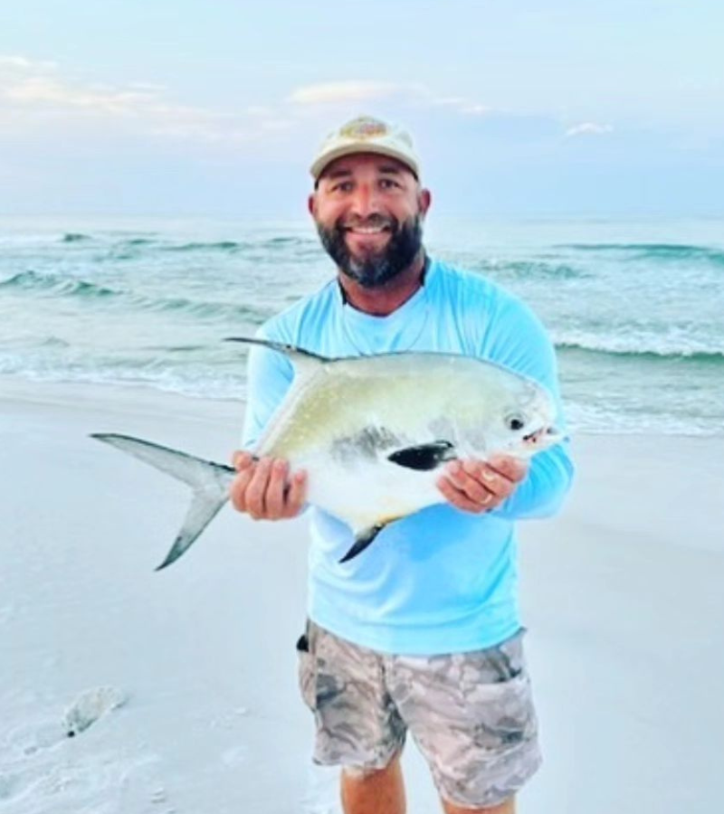 Photo of angler holding a gorgeous pompano caught in the surf with a running rig