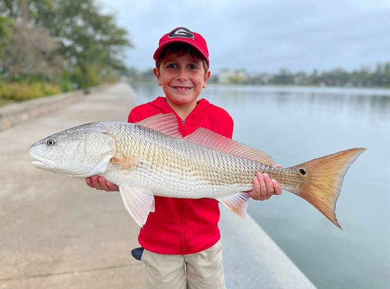 Photo of a young angler holding a trophy redfish